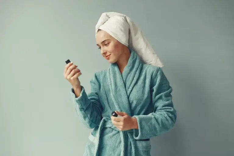 Femme en peignoir appliquant un soin